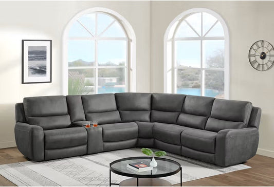 Gray sectional sofa in a living room with large windows and decor.